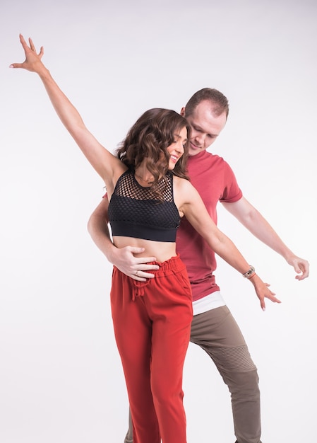 Dançarinos de salsa, kizomba e bachata em fundo branco. Conceito de dança social.