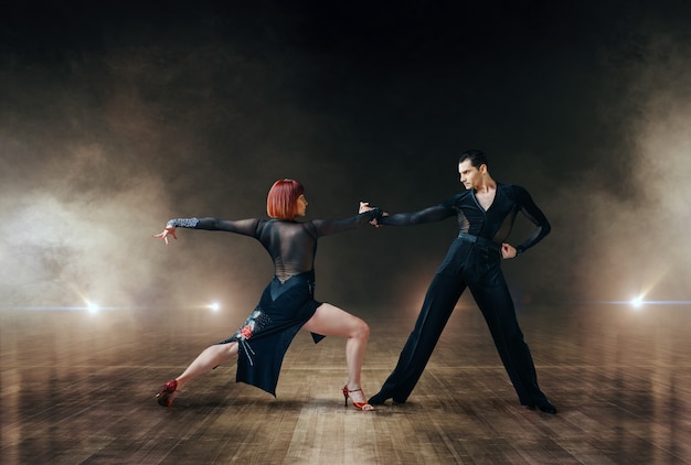 Dançarinos elegantes em trajes, dança latina ballrom no palco. parceiros masculinos e femininos em pares profissionais dançando na cena do teatro