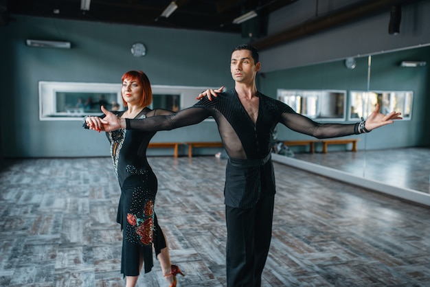 Foto dançarinos em fantasias no treinamento de dança ballrom em classe. parceiros masculinos e femininos em pares profissionais dançando no estúdio