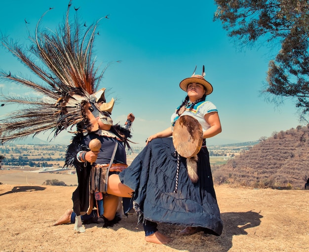 Dançarinos mexicanos posando para a câmera com tufos e vestido pré-hispânico