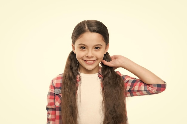 Dando ao cabelo uma perfeição sedosa Menina bonita com penteado longo Menina com penteado elegante de rabo de cavalo Criança com cabelo moreno Modelo de cabelo pequeno com visual de beleza Salão de cabeleireiro para crianças