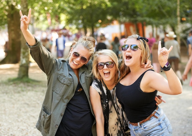 Dando chifres Três amigas festejando em um festival de música ao ar livre