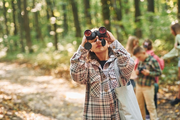 Dando un paseo Niños en el bosque verde durante el día de verano juntos