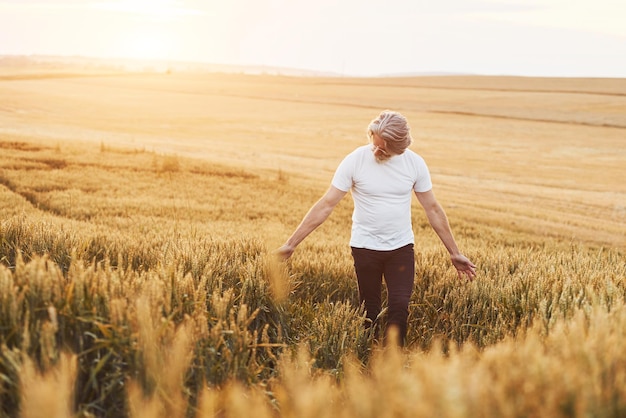 Dando un paseo Retrato de un anciano elegante con cabello gris y barba en el campo agrícola