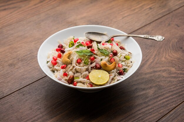 Dapde Pohe ist ein typisches Maharashtrian-Frühstück, das mit einer dünnen Auswahl an Poha und frischer Kokosnuss mit Chili, Erdnüssen und Nüssen zubereitet wird. in einer Schüssel oder einem Teller serviert. selektiver Fokus