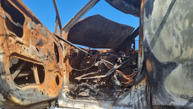 Foto dargestellt ist ein ausgebranntes auto mit dem schriftzug „feuer“ an der seite.