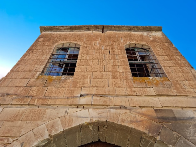 Das alte Steinhaus oben auf der Straße mit zwei Fenstern