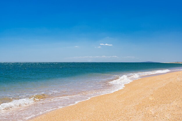 Das azurblaue türkisfarbene Meer mit gelbem Sand aus Muscheln