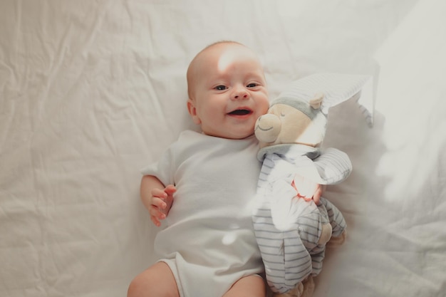 Das Baby liegt in seinem Bettchen und schaut in die Kamera Lifestyle Ein glückliches Kind Kinderartikel