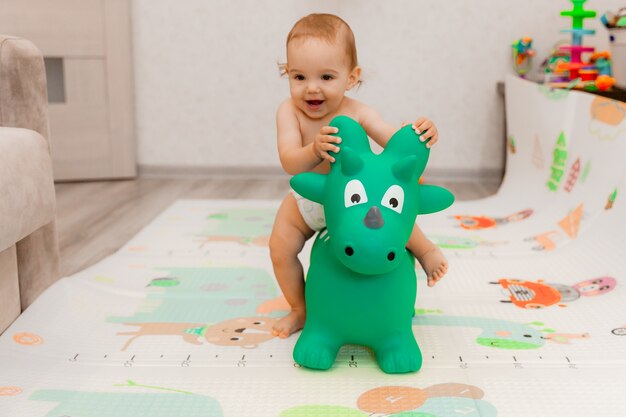 Das Baby schaukelt auf einer Bahre in Form eines Drachen in seinem Zimmer. Spielzeug Drache.