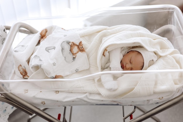 Das Baby schläft am ersten Lebenstag in einer neugeborenen Decke