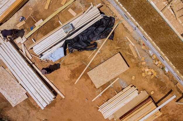 das Baumaterial ein Holzgebäude mit einem Stapel von Holzbalken für den Bau