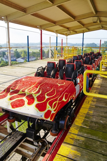 Das Bild eines Achterbahnautos mit Hot-Rod-Flammen sitzt verlassen in einem abgeschirmten Pavillon auf der Fahrt