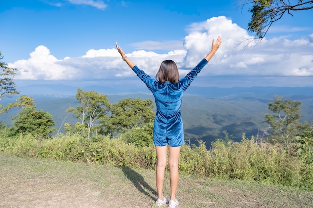 Das Bild hinter den Frauen, die ihre Arme heben, sah auf die Berge und Wolken bei Doi Samer Dao