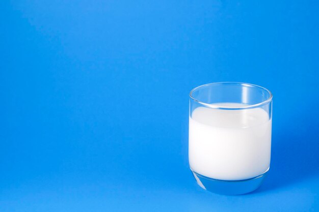 Das Bild von Milch in einem Glas hat eine Komposition. Auf der rechten Seite steht ein Glas Milch