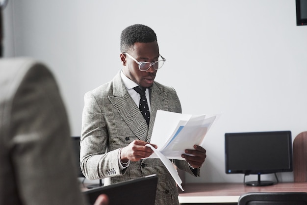 Das Bild von zwei jungen Afroamerikanergeschäftsmännern, die bei einer Sitzung im Büro aufeinander einwirken