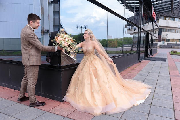 Das Brautpaar läuft durch die Stadt. Braut und Bräutigam kommen. Schöne Hochzeit