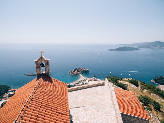 Das Brautpaar sitzt umarmt auf der Aussichtsplattform mit Blick auf die Insel Sveti