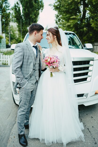 Das Brautpaar vor der Limousine
