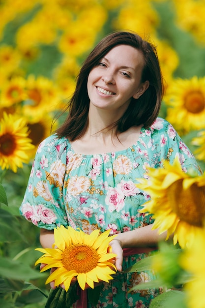 Das brünette Mädchen in einem Sonnenblumenfeld