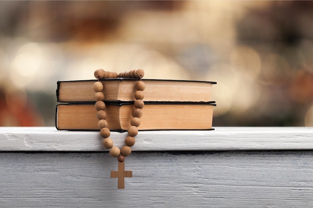 Das Buch der Liturgie der katholischen Kirche und Rosenkranzperlen auf dem Holztisch