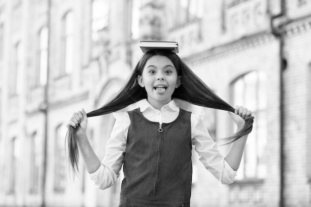 Das Buch lehrt, wie man selbst eine Frisur kreiert Kind hält lange Haare Haarpflegebuch Schönheitsschule Ausbildung für professionelle Friseure Kurse zum Schneiden Kurse zum Stylen und Pflegen der Haare