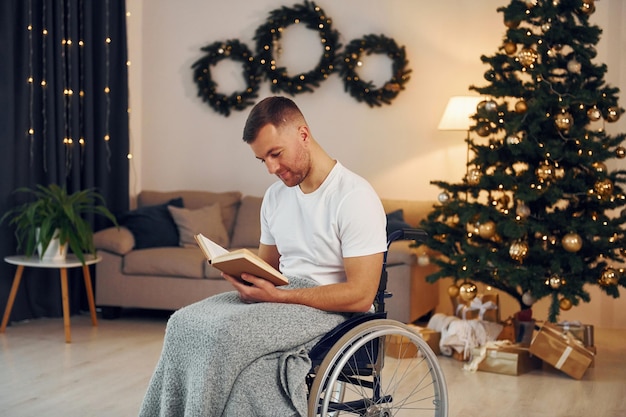 Das Buch lesen Das neue Jahr kommt Der behinderte Mann im Rollstuhl ist zu Hause