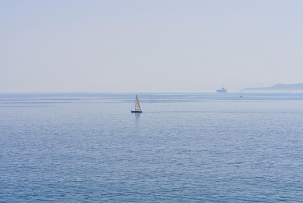 Foto das einsame segelboot am horizont im meer