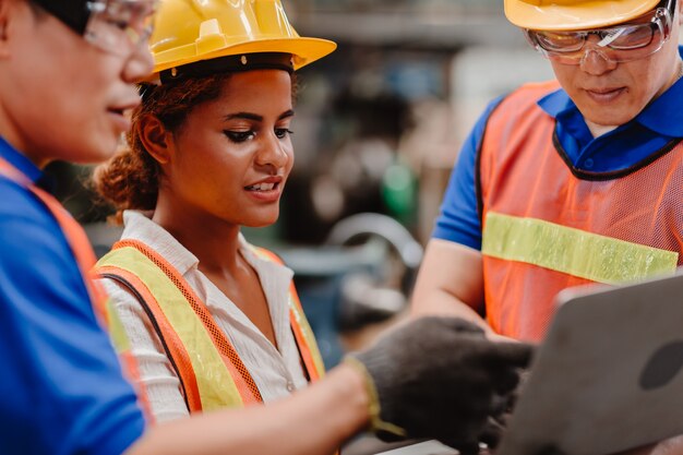 Das Engineer Team Mix Race arbeitet in der Schwerindustrie mit der Diskussion über Laptops zusammen. Schließen Sie sich der Engineer Teamwork an.