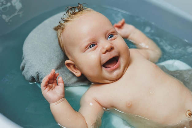 Das erste Bad des Babys Die Pflege eines Neugeborenen Das Baden eines Babys in einer Badewanne