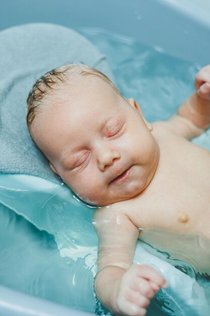 Das erste Bad des Babys Die Pflege eines Neugeborenen Das Baden eines Babys in einer Badewanne