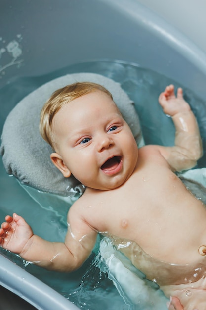 Das erste Bad des Babys Die Pflege eines Neugeborenen Das Baden eines Babys in einer Badewanne