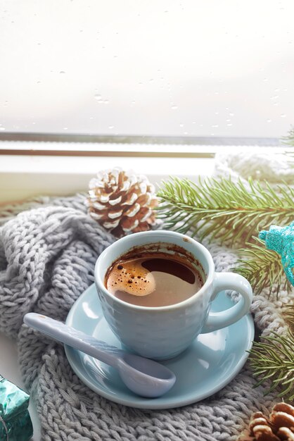 das Fenster mit einer Tasse heißes Getränk