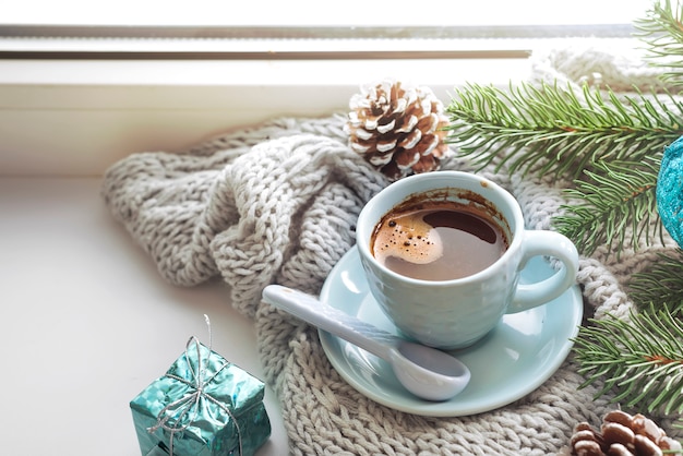 das Fenster mit einer Tasse heißes Getränk