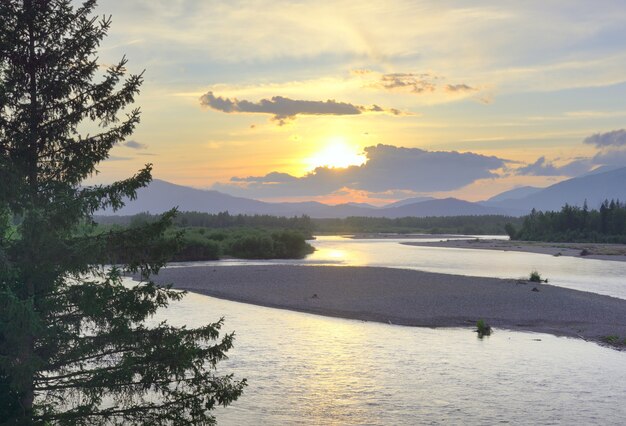 Das Flussufer im Altai-Gebirge unter dem goldenen Abendhimmel. Sibirien, Russland