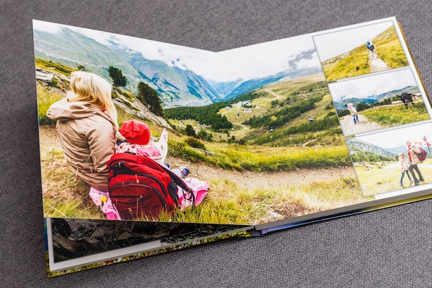 das fotobuch geöffnet, reisen in der schweiz, auf grauem hintergrund