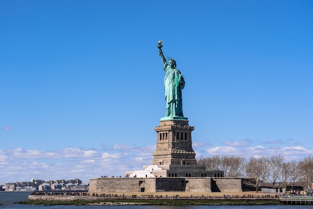 Das Freiheitsstatue unter der Wand des blauen Himmels, Lower Manhattan, New York City