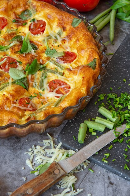 Das Frühstück am Sonntagmorgen. Omelett im Ofen mit grünen Bohnen, Tomaten, Kräutern und Käse