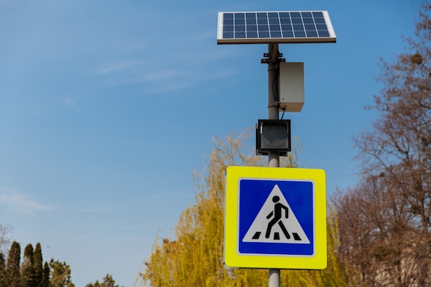 Das Fußgängerüberwegzeichen, das von Sonnenkollektoren angetrieben wird, die über Verkehrszeichen und Regeln installiert sind