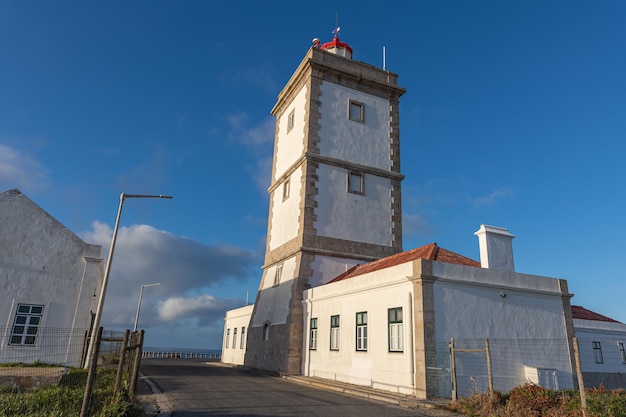 Das Gebäude des Küstenleuchtturms auf einem Hügel am Meer vor dem Hintergrund des blauen Himmels