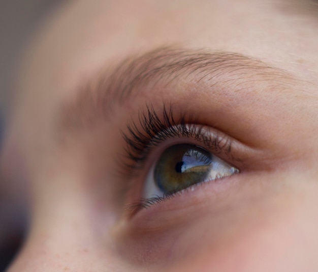 das geöffnete Mädchenauge mit langen Wimpern hautnah mit Stadtreflexion