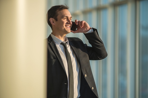 Das Geschäftsmanntelefon in der Nähe der Säule