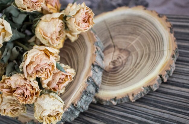 Das geschnittene Holz mit getrockneten Rosen; trockene Rosen auf einem geschnittenen Baum. Vintage Dekoration