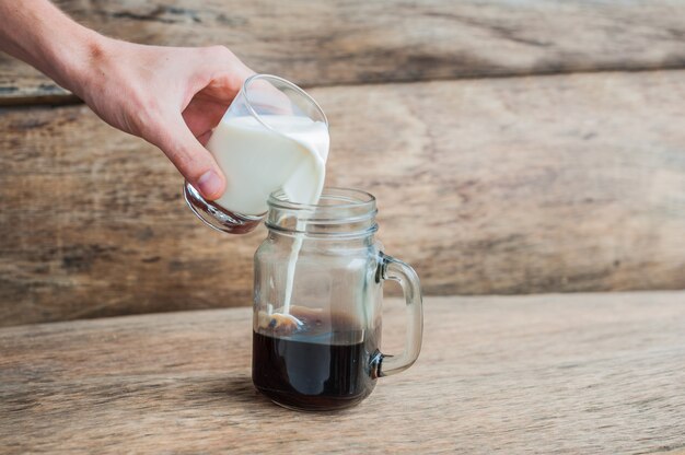 Das Glas schwarzen Kaffee und ein Glas Milch