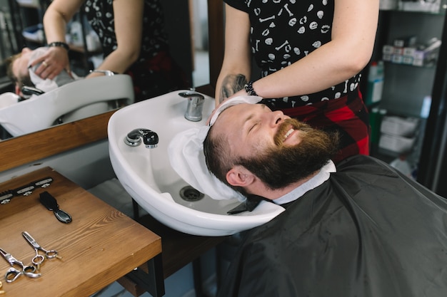 Das Haar des Friseurs, welches das Haar des Friseurs im Friseursalon wäscht.