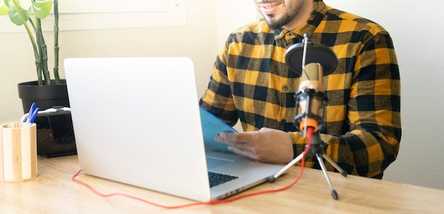 Das halbe Gesicht eines Mannes erscheint in einem Büro mit einem Ordner in der Hand, während er einen Podcast aufzeichnet