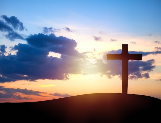 Das Holzkreuz auf einem Berg mit Sonnenuntergang im Hintergrund