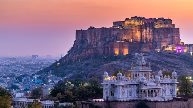 Das Jaswant Thada und Mehrangarh Fort im Hintergrund bei Sonnenuntergang. Das Jaswant Thada ist ein Kenotaph in Jodhpur. Es wurde für die Einäscherung der königlichen Familie Marwar, Jodhpur, verwendet. Rajasthan, Indien