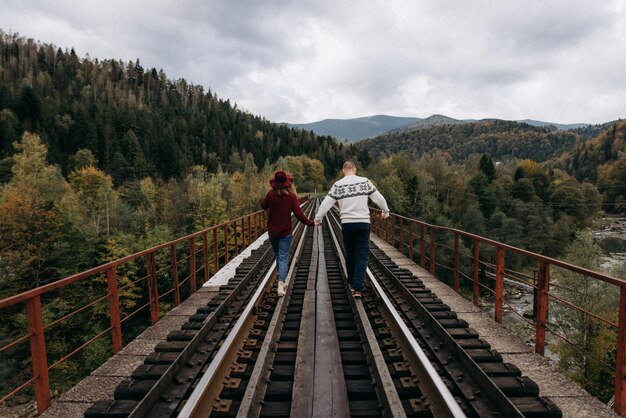 Das junge Paar zu Fuß auf einer Bahnstrecke