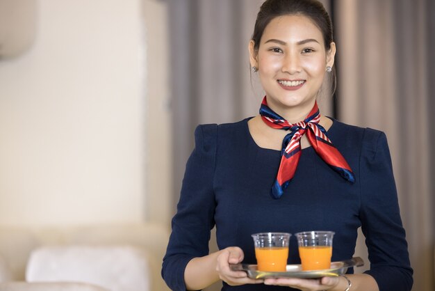 Das Kabinenpersonal versorgt den Passagier im Flugzeug mit Wasser. Konzept für Flugverkehr und Tourismus.